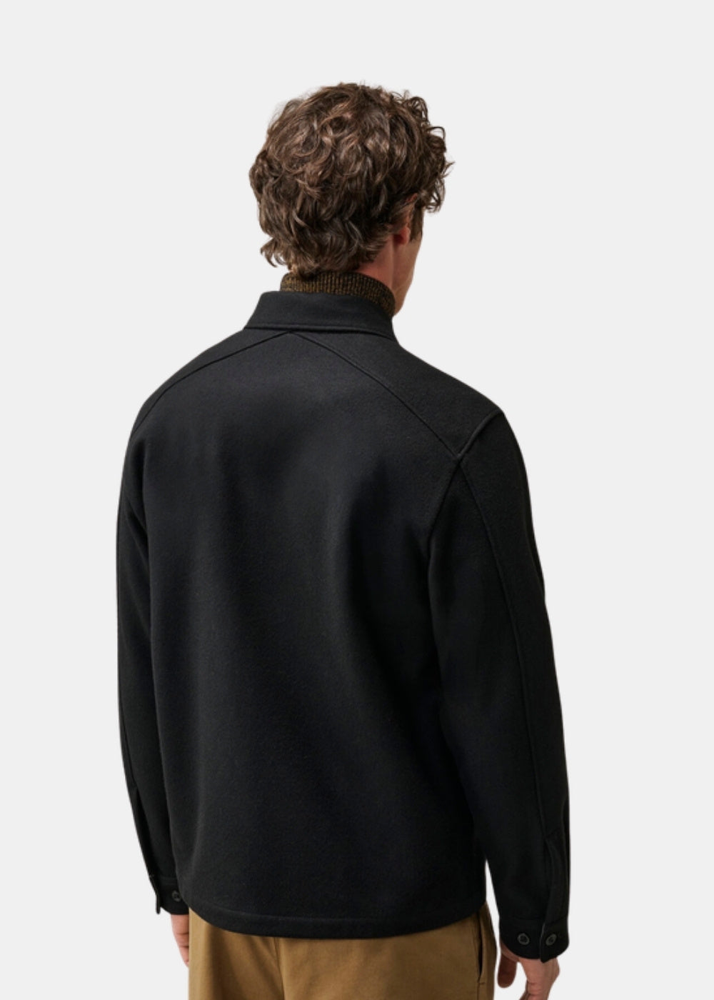 Porté de dos d'une surchemise noire C.P. Company en laine feutrée montrant la coupe classique et la surface dense et mate du tissu.