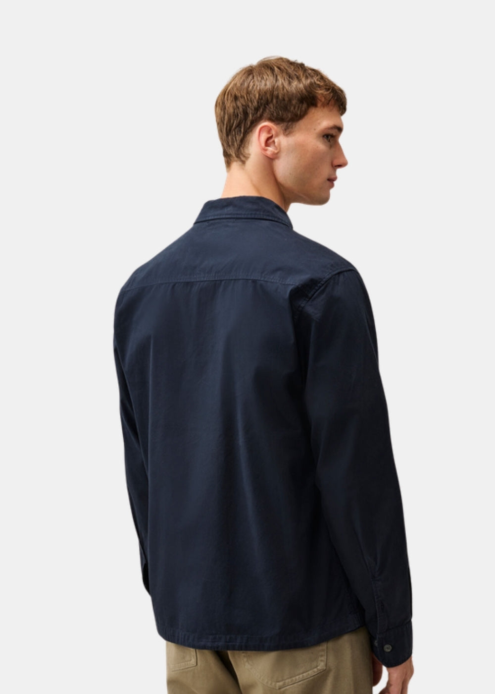 Porté de dos d'une surchemise zippée marine C.P. Company en gabardine, montrant la coupe classique et la tenue nette du tissu.