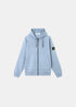 Sweat à capuche zippé Stone Island 100% coton biologique bleu ciel coupe regular teint en pièce SS26 vue de face