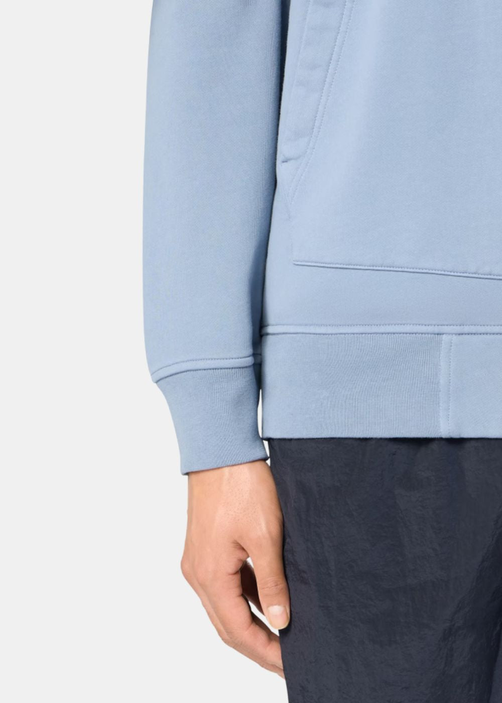 Détail poches obliques et bande côtelée du sweat zippé Stone Island coton biologique bleu ciel SS26