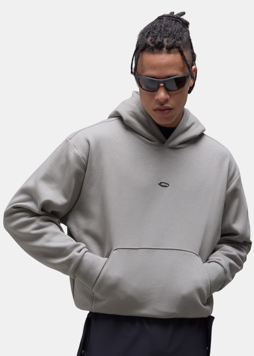 Gros plan porté du sweat à capuche homme Oakley Metal Rise Hoodie gris montrant la poche kangourou et le logo poitrine