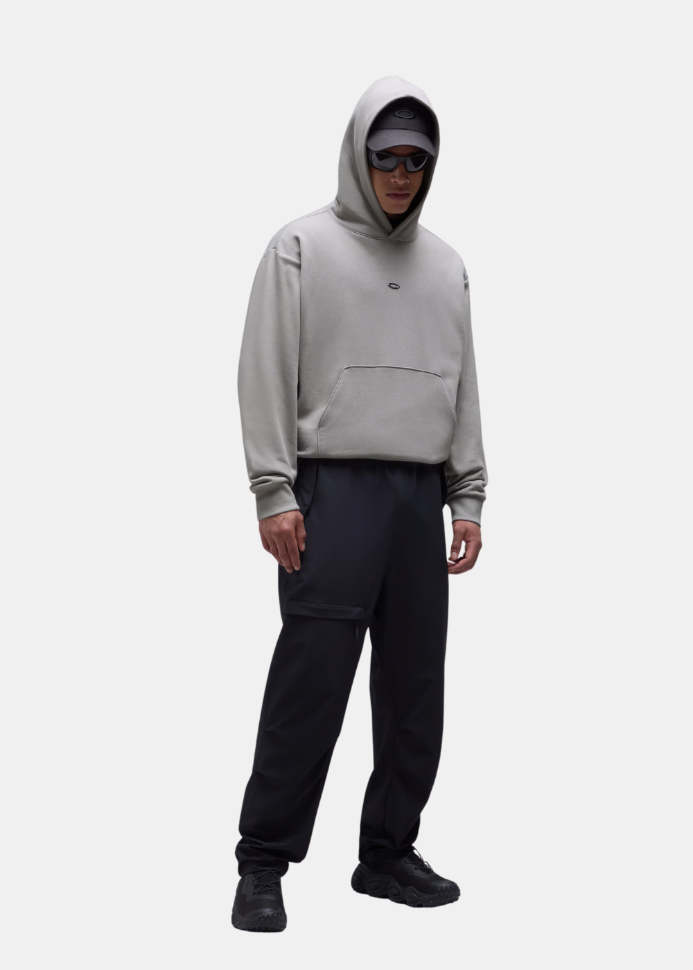 Sweat à capuche homme Oakley Metal Rise Hoodie gris porté de face avec la capuche rabattue sur une casquette