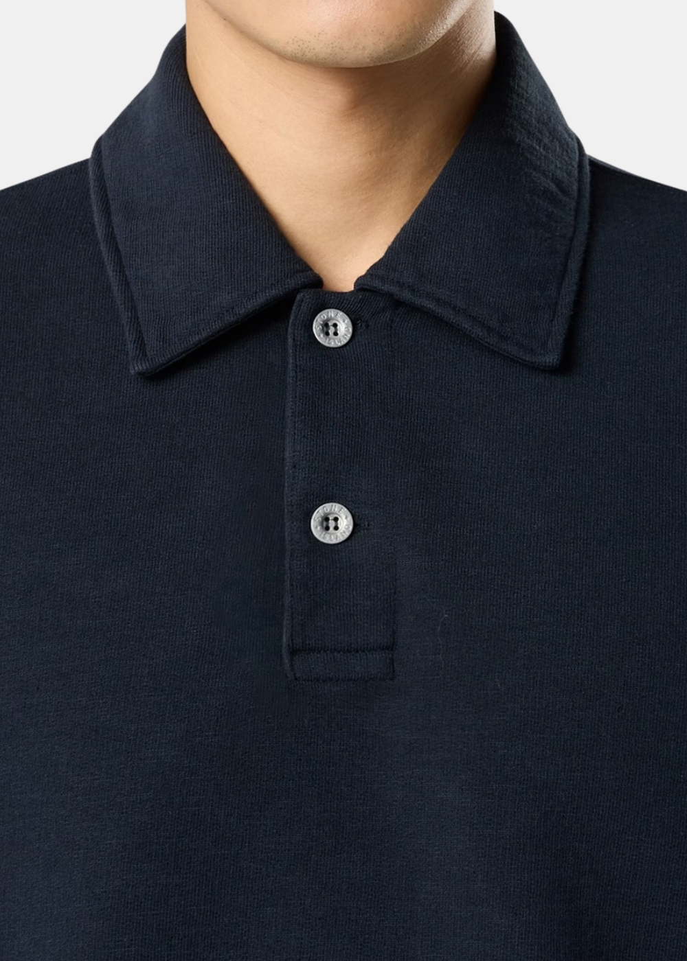 Gros plan sur le col polo boutonné à patte deux boutons gravés du sweat bleu marine Stone Island