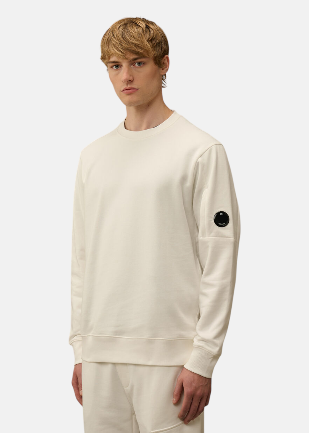 Homme portant le sweat C.P. Company col rond blanc cassé en molleton.