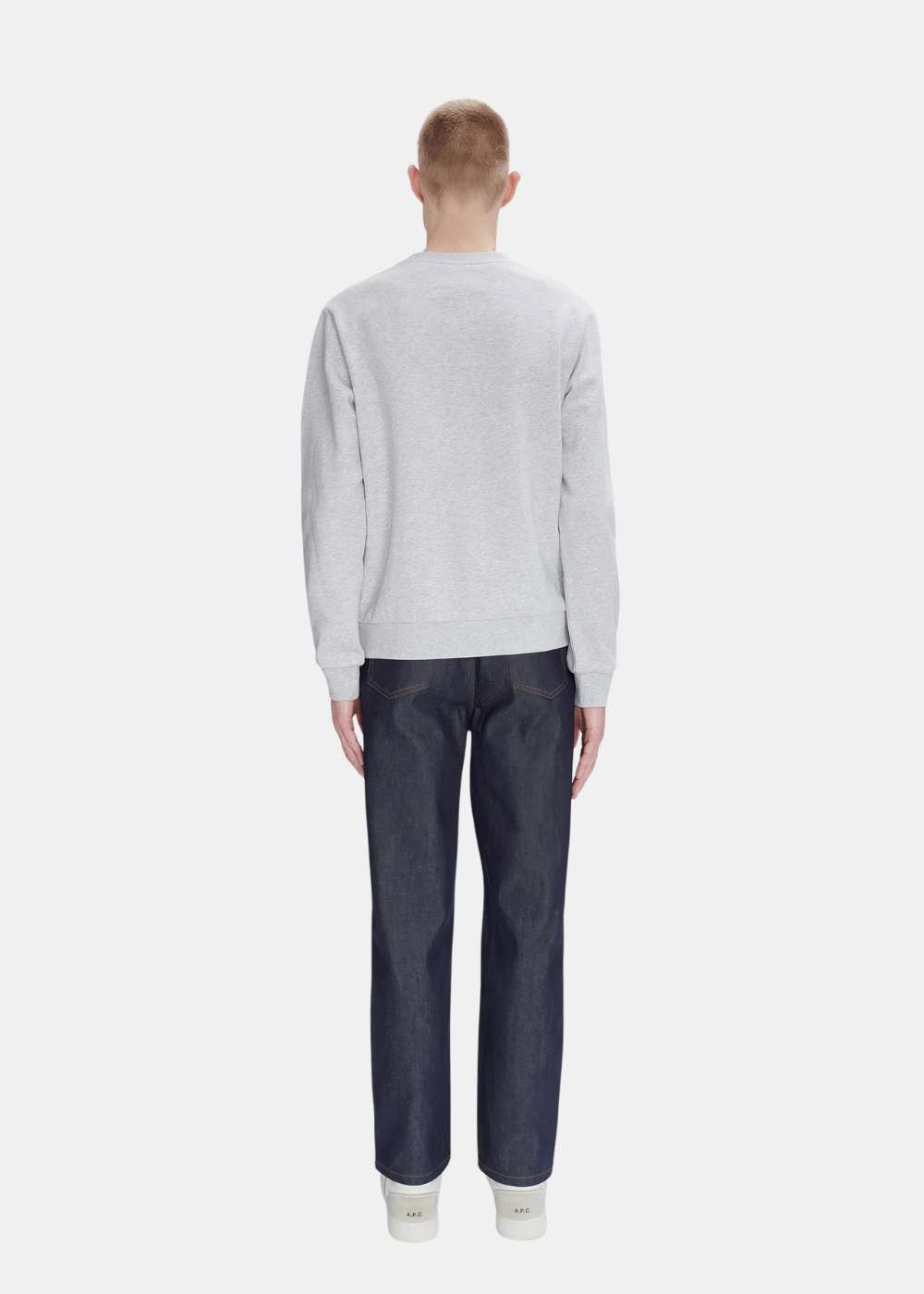 Look complet de dos montrant un mannequin portant le sweat gris chiné APC avec un jean brut bleu foncé