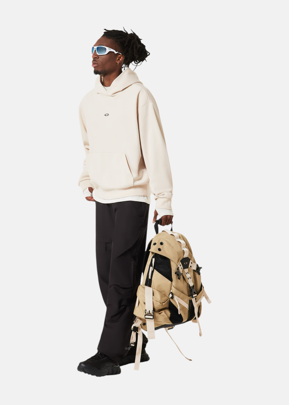 Silhouette complète avec hoodie beige Oakley, pantalon de jogging assorti et baskets de sport.