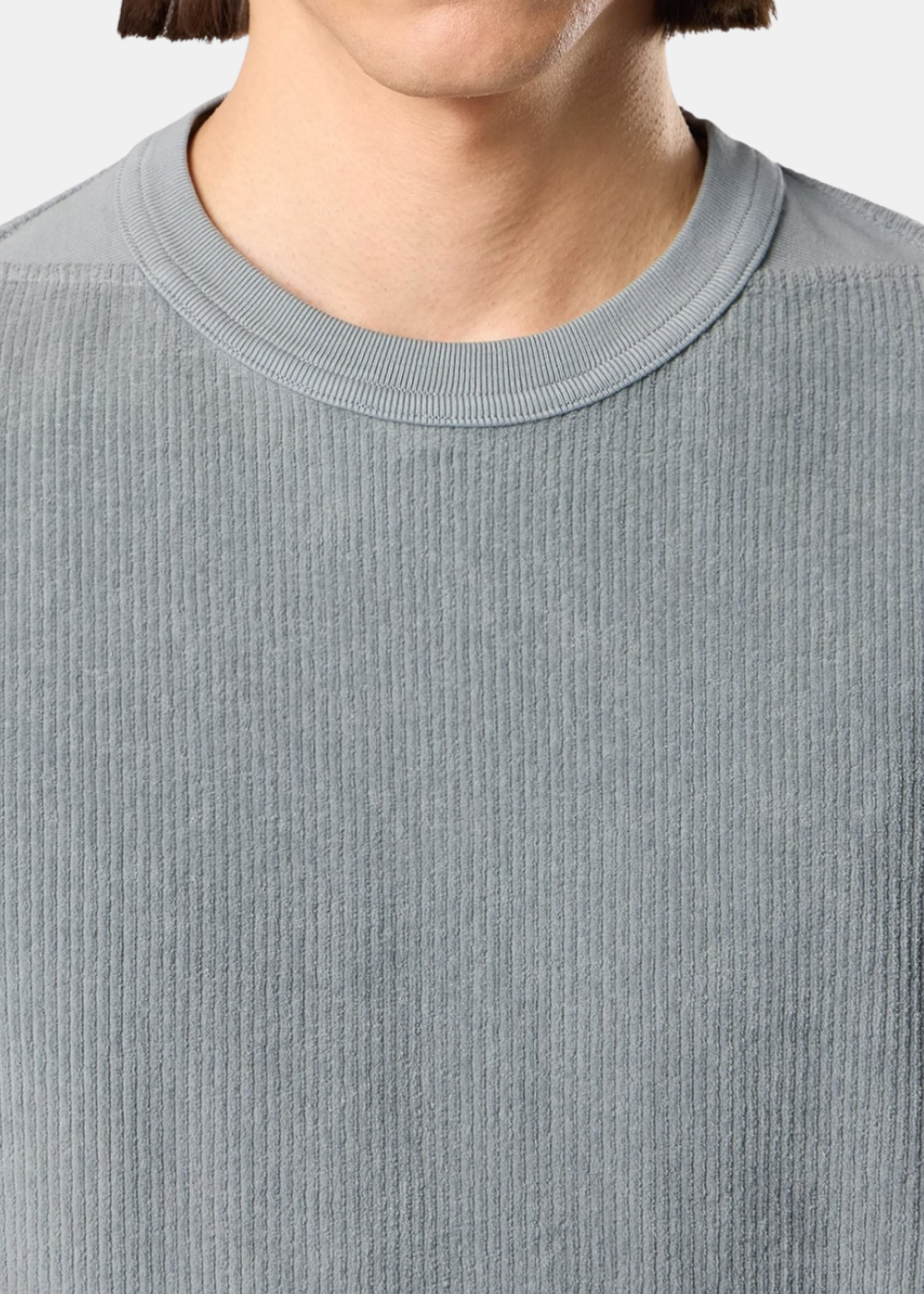 Gros plan sur le col ras du cou d'un sweat en jersey velours côtelé gris Stone Island porté