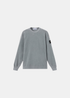 Packshot du sweat en jersey velours côtelé gris Stone Island avec badge sur la manche gauche