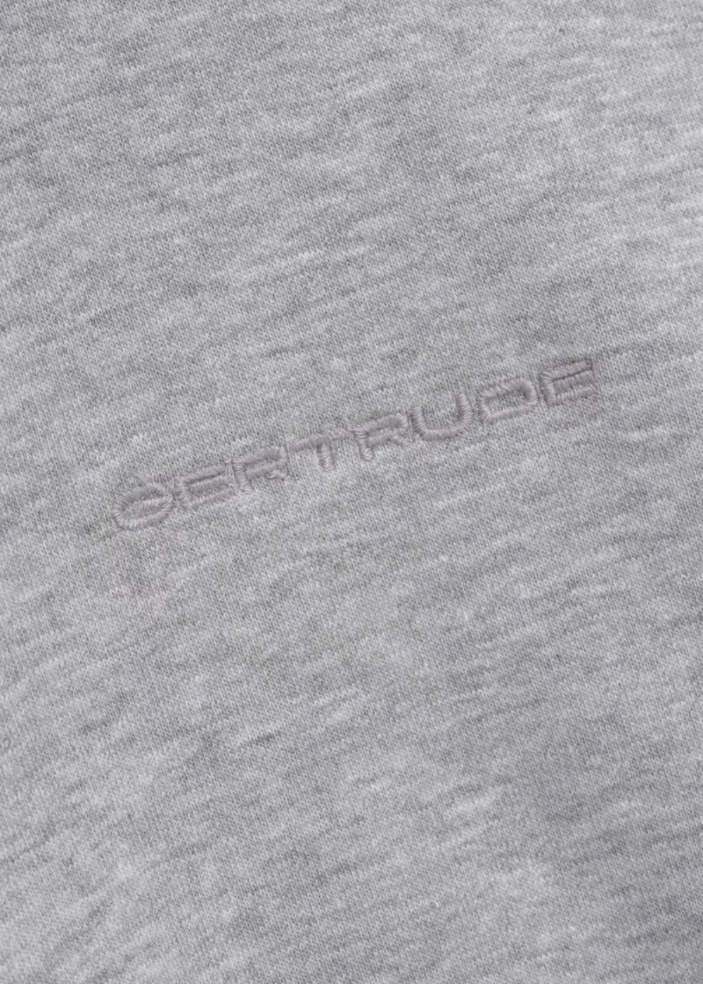 Gros plan sur le logo Gertrude brodé ton sur ton sur la poitrine du sweat gris   