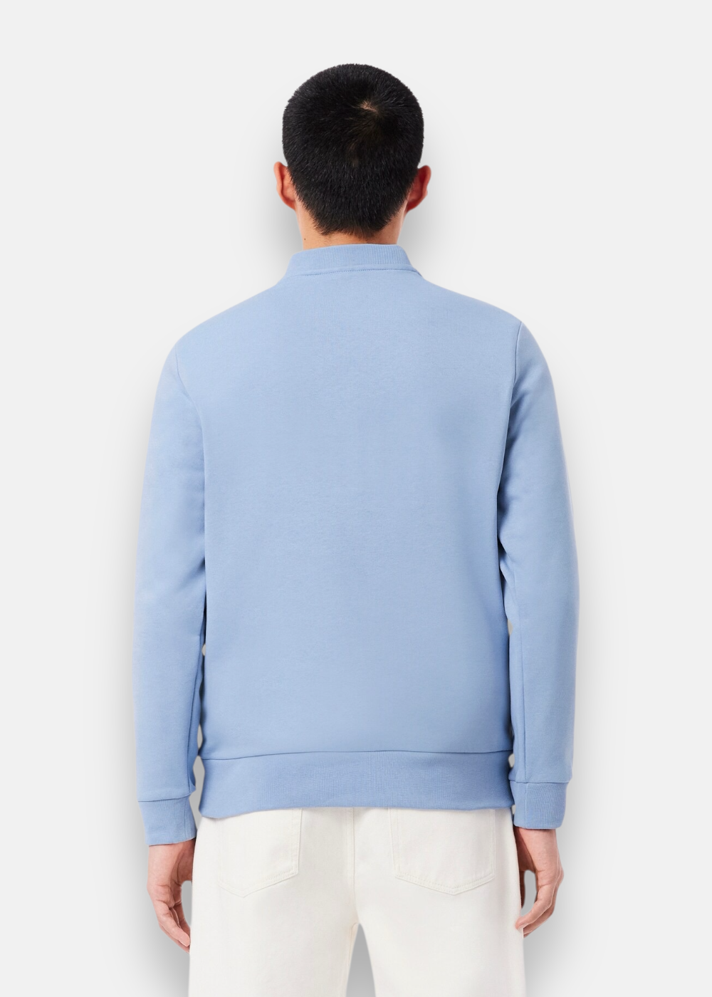 Vue de dos d'un homme portant le sweatshirt bleu clair Lacoste montrant la coupe classic fit.