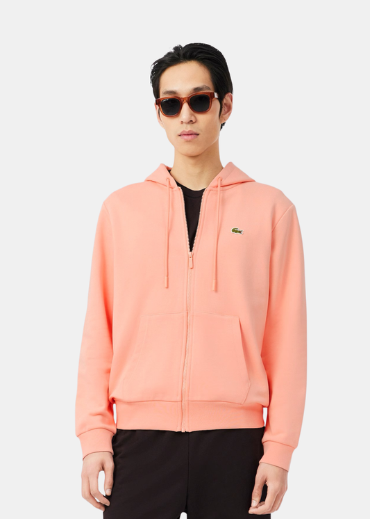Sweatshirt pour homme zippé à capuche rose corail Lacoste avec logo crocodile, porté de face