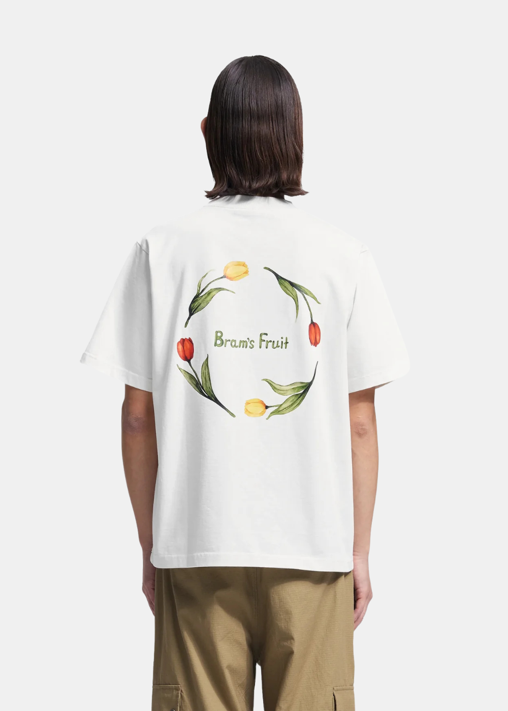 Homme de dos portant le t-shirt blanc Bram’s Fruit Flora 2.0 illustré d'une couronne de tulipes et du logo.