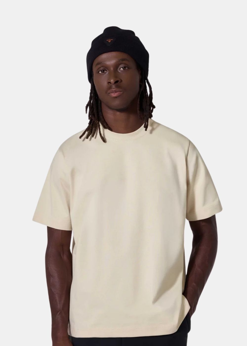 Homme de face portant le t-shirt beige ample Darryl Dots de Gertrude + Gaston avec bonnet noir.