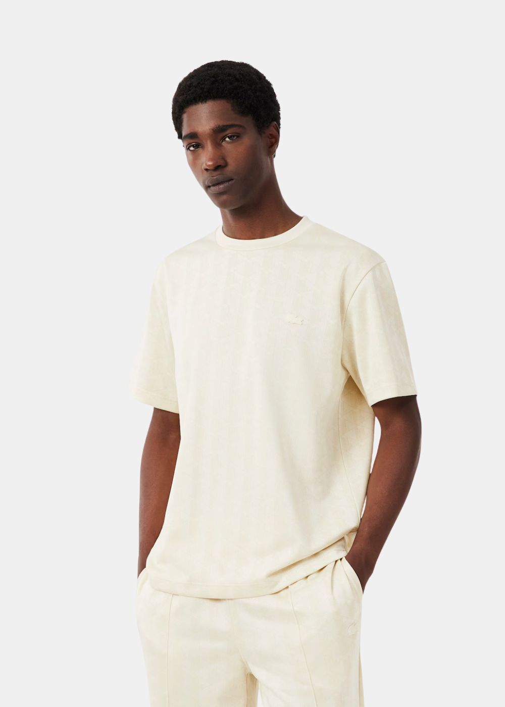 Mannequin portant le t-shirt col rond Lacoste crème en maille jacquard monogramme.