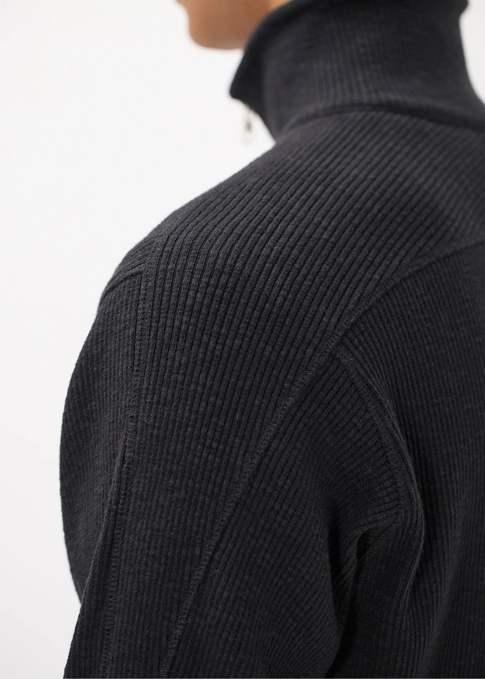 Gros plan sur la structure de la maille jersey et les coutures de l'épaule du gilet Homme noir.