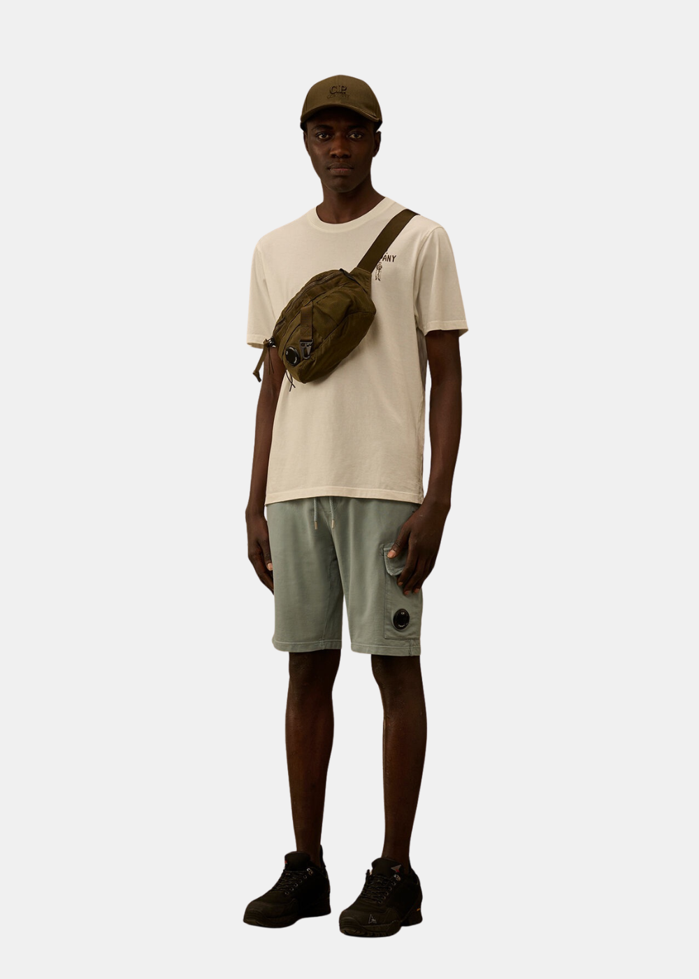 Look complet Homme avec t-shirt beige C.P. Company, short cargo vert, sacoche et casquette