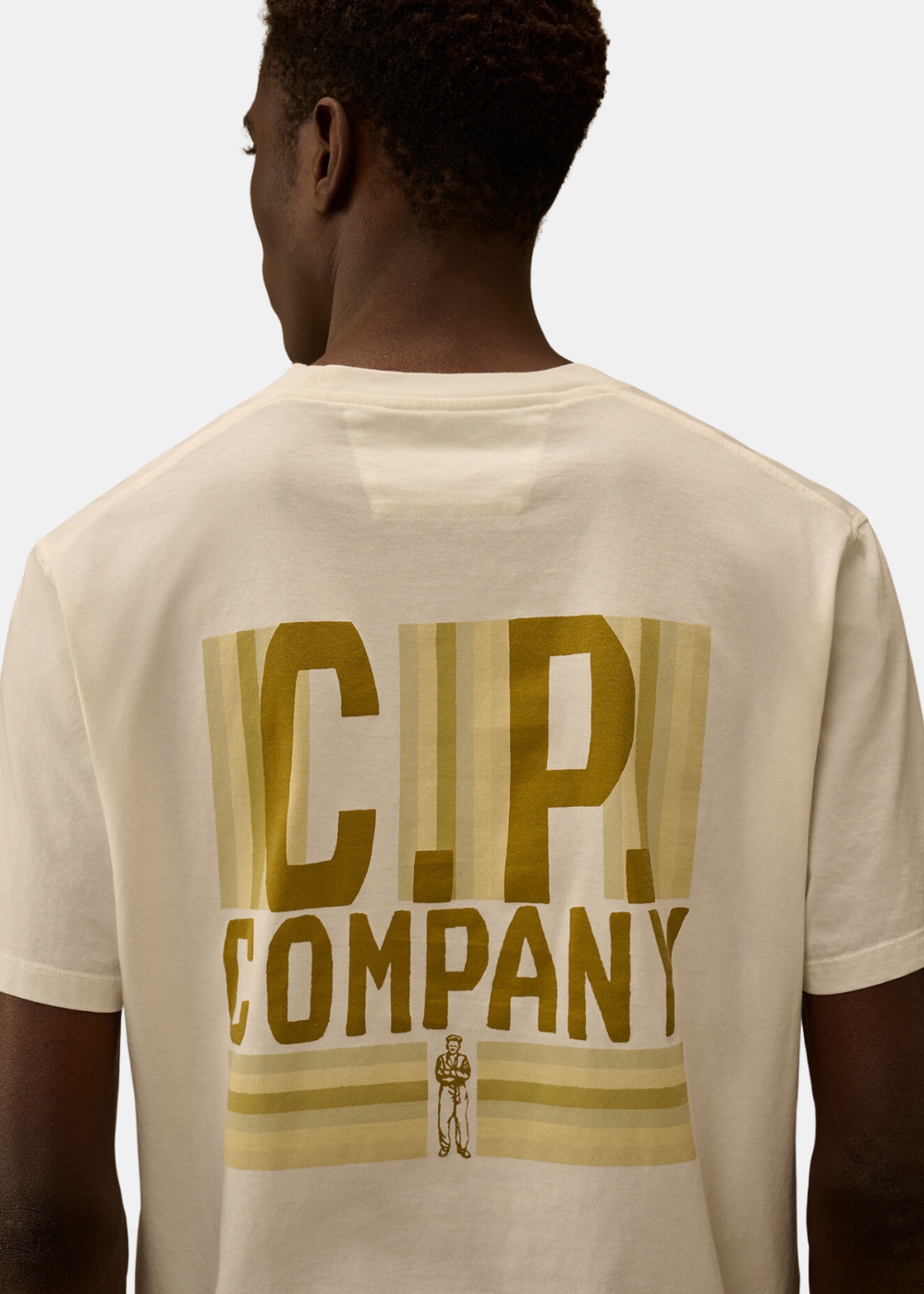 Gros plan sur le graphisme arrière du t-shirt beige C.P. Company et le détail de l'impression