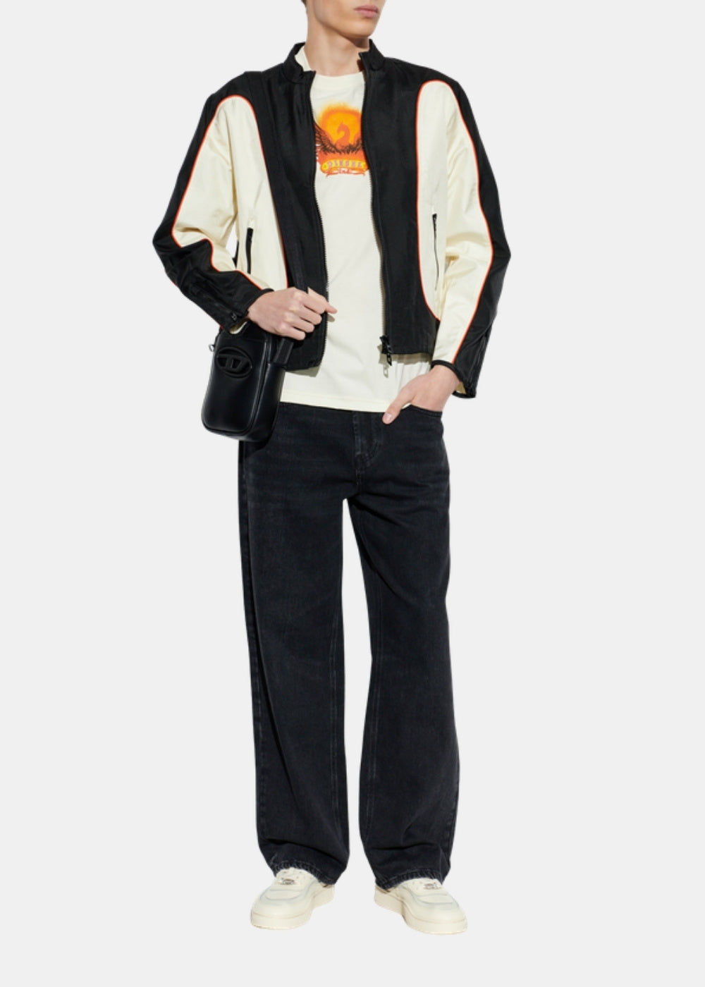 Porté en pied d'un T-shirt beige Diesel avec pantalon sombre ample, veste bicolore noir et crème et sneakers claires.