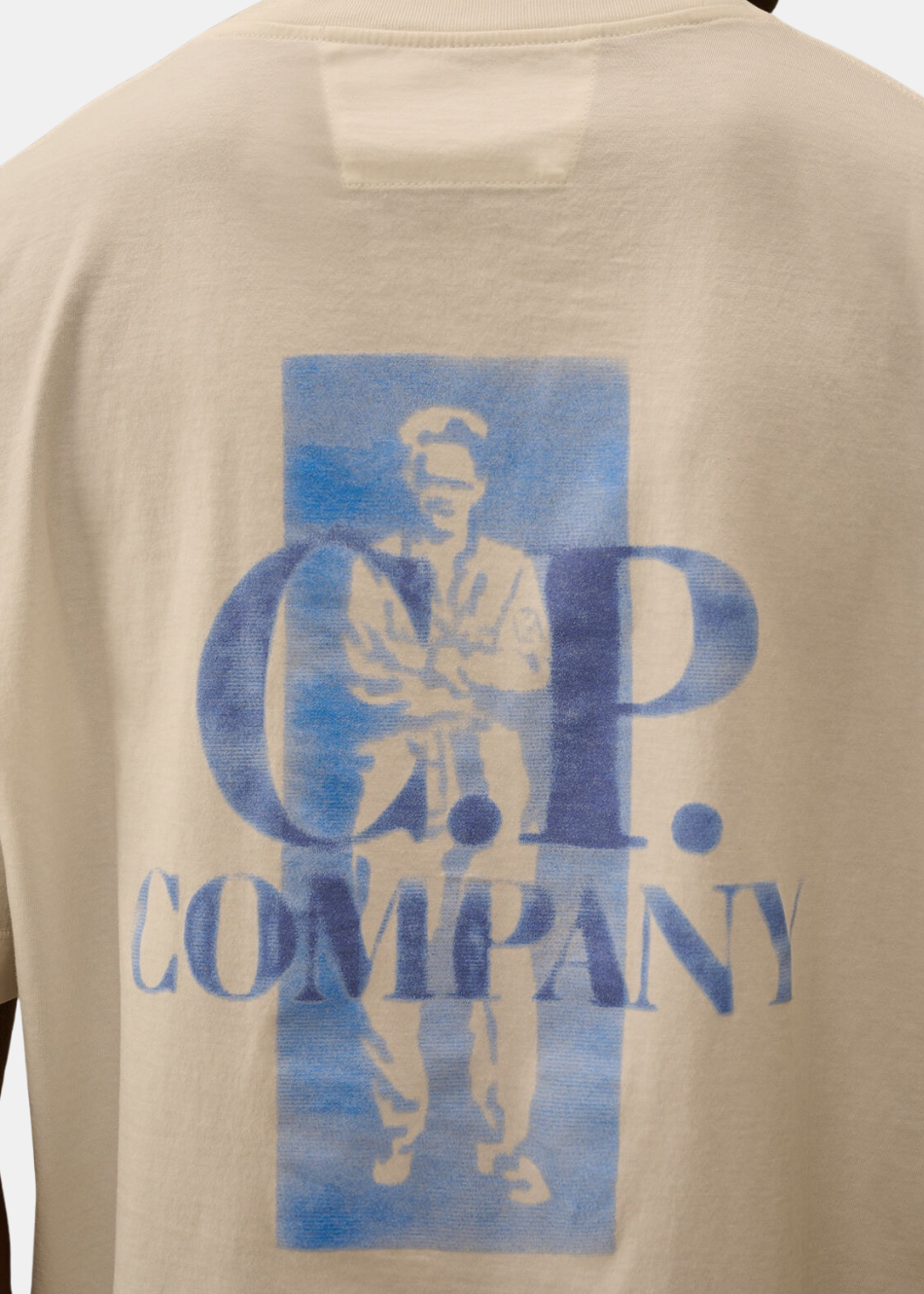 Gros plan sur le dos du t-shirt blanc montrant les détails de l'imprimé bleu British Sailor