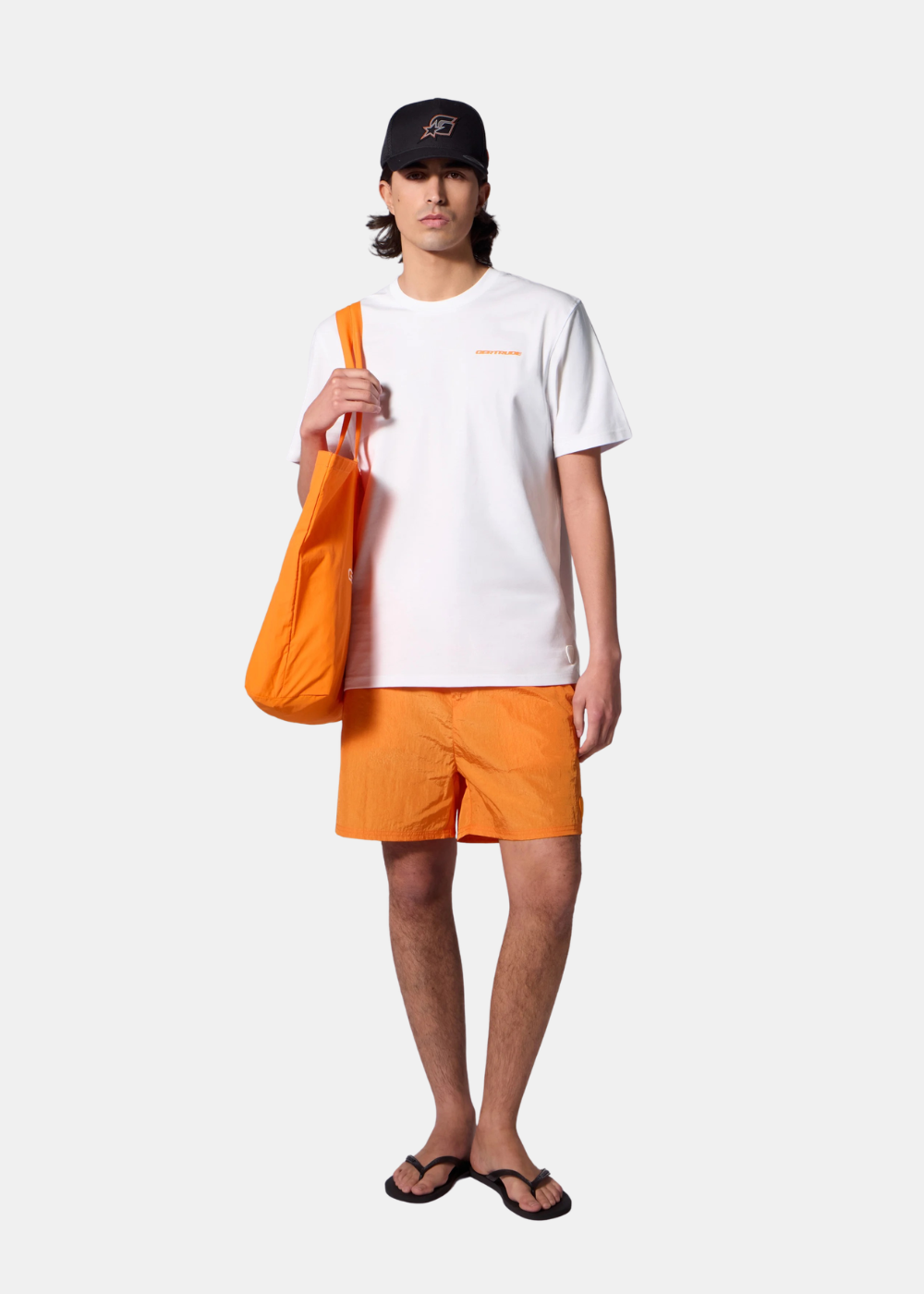 Silhouette complète avec t-shirt blanc Gertrude, short orange, casquette noire et sac cabas assorti