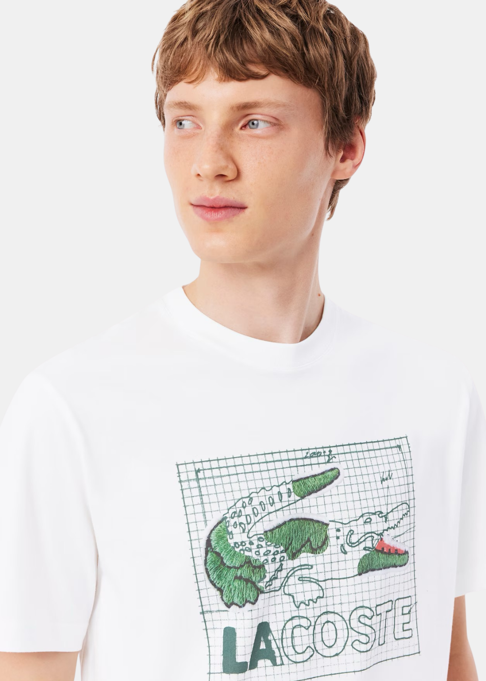 Gros plan sur le buste d'un mannequin portant le t-shirt blanc Lacoste avec motif graphique crocodile vert