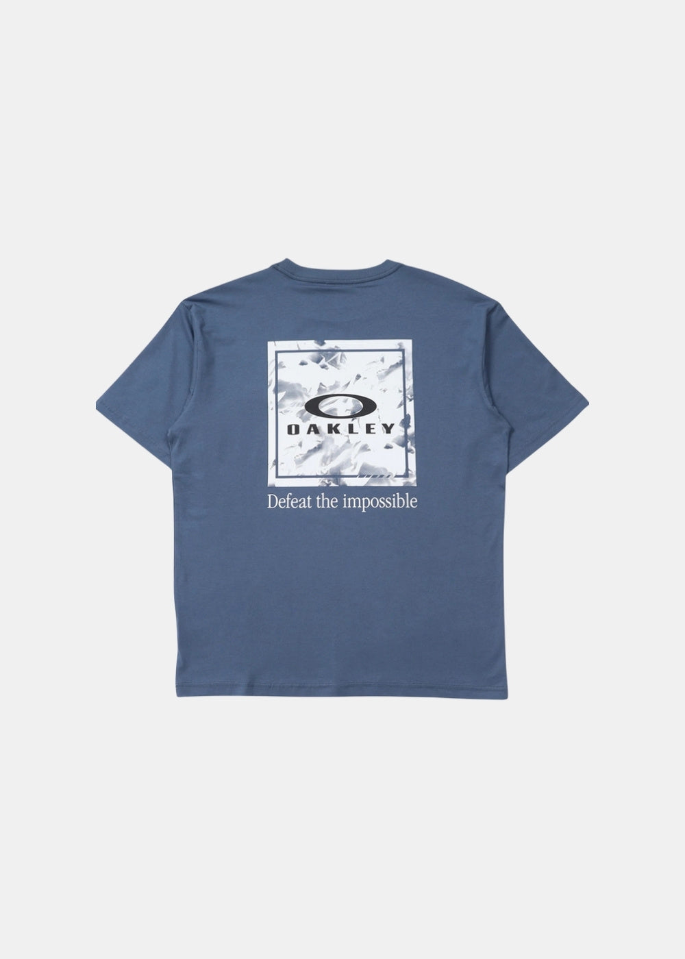 Packshot de dos d'un t-shirt bleu Oakley avec grand cadre imprimé, ellipse signature et devise Defeat the Impossible.