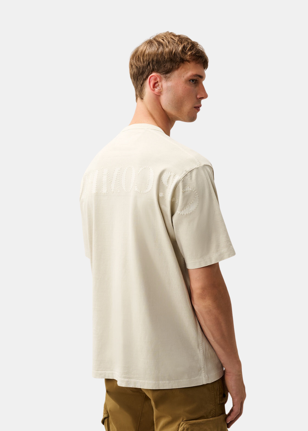 Vue de trois-quarts dos portée du t-shirt beige C.P. Company mettant en valeur la broderie aux épaules