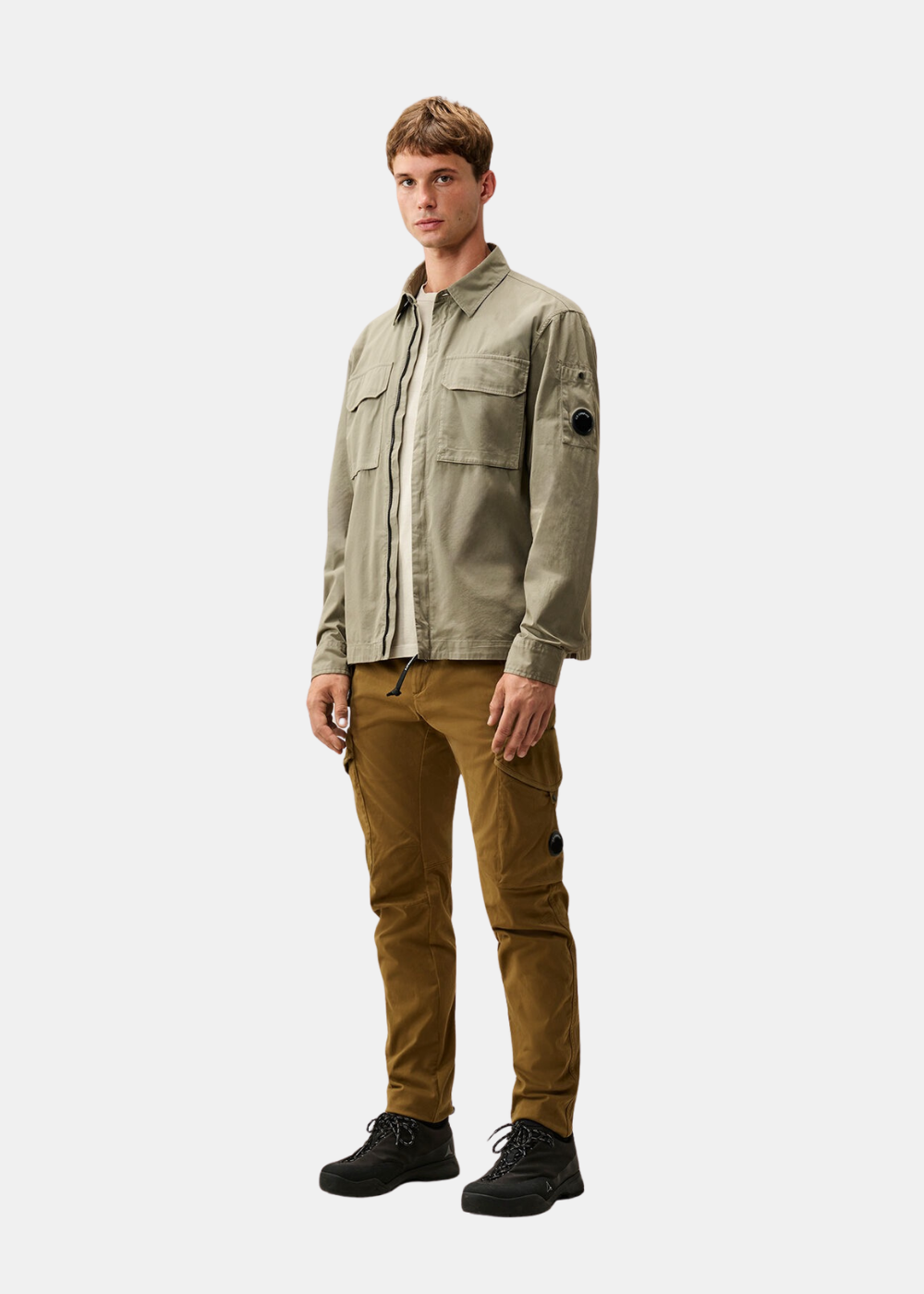 Silhouette portée du t-shirt beige C.P. Company sous une surchemise olive avec un pantalon cargo camel