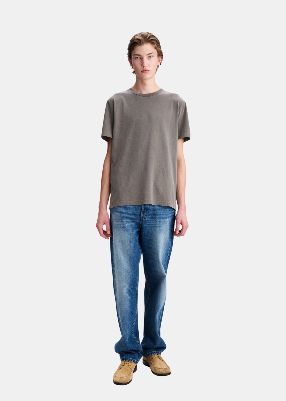 Mannequin homme de face en pied portant le t-shirt gris délavé A.P.C. avec un jean bleu délavé et des chaussures de ville en daim
