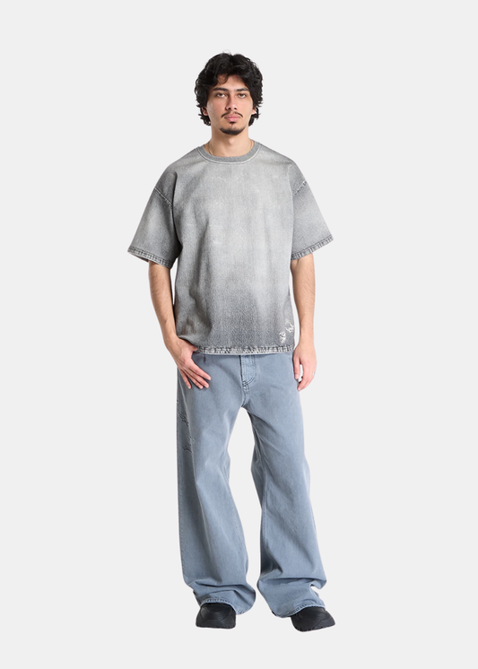 Look complet homme avec t-shirt Diesel gris effet délavé et jean large bleu porté de face.