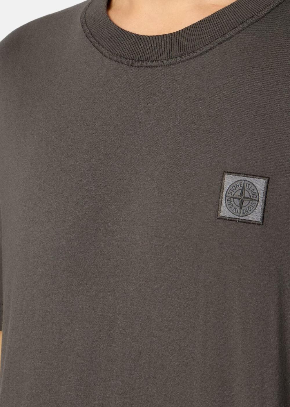 Gros plan sur le buste d'un t-shirt gris Stone Island FISSATO avec patch logo brodé et col rond côtelé.