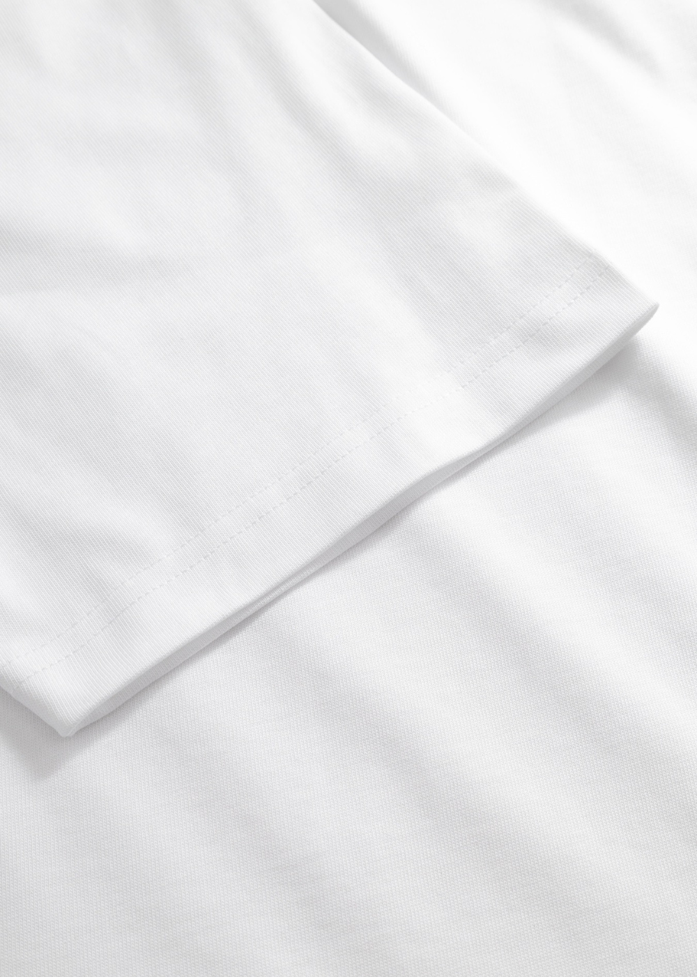 Zoom sur les finitions de couture double aiguille au bas de la manche du t-shirt Homme blanc.