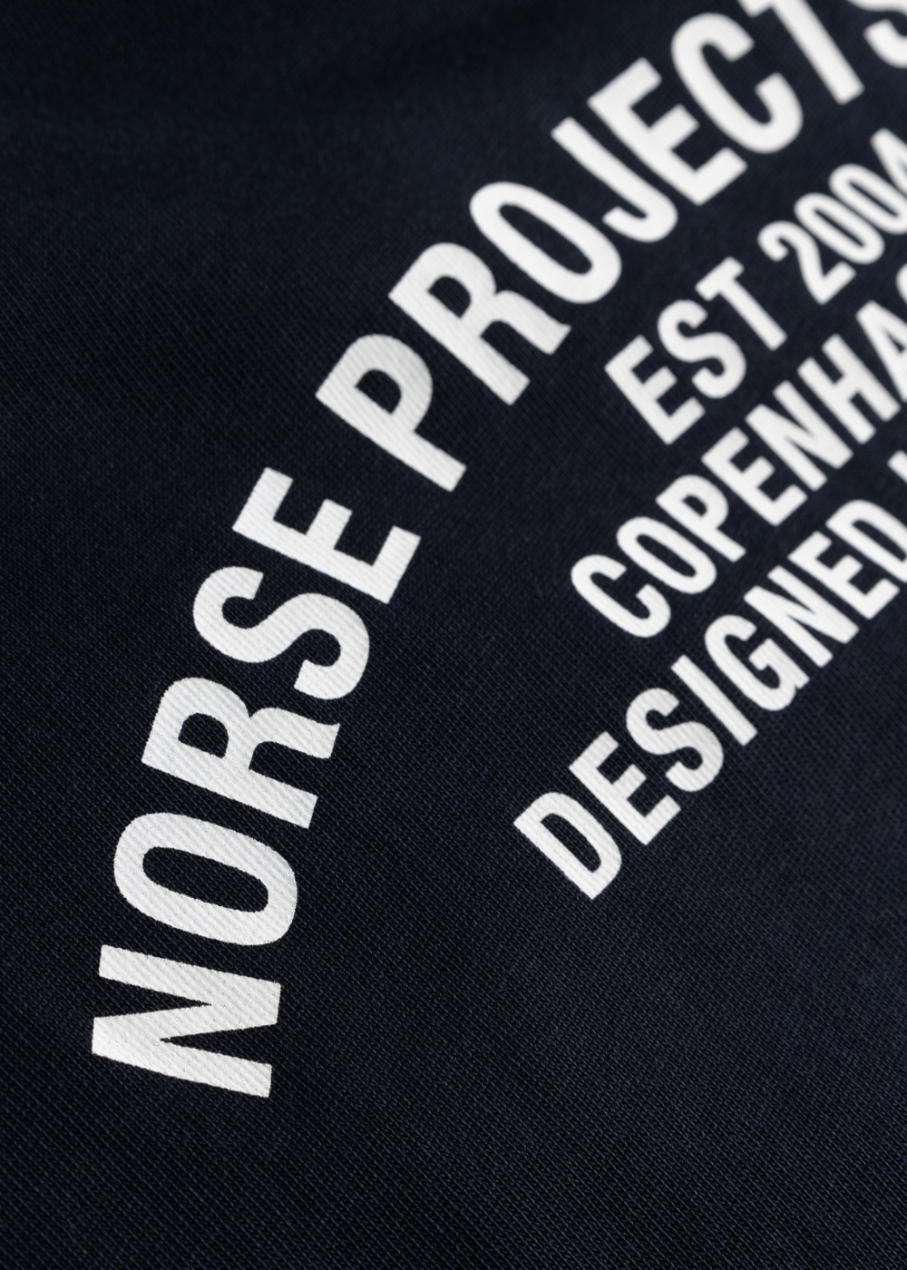 Porté du t-shirt Homme Norse Projects marine montrant l'imprimé blanc graphique dans le dos.