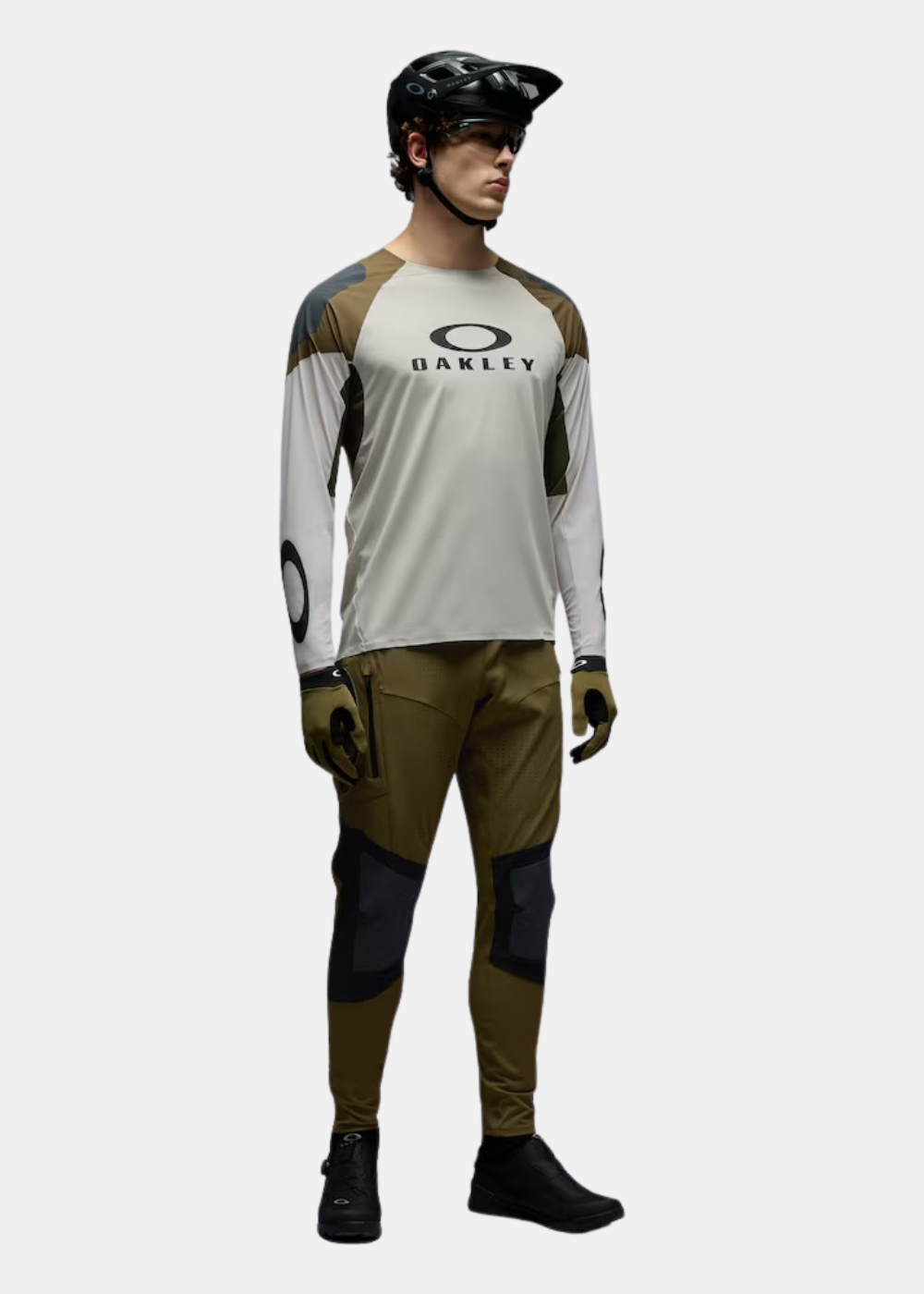 Mannequin de face portant le t-shirt Oakley beige et vert avec un pantalon technique assorti