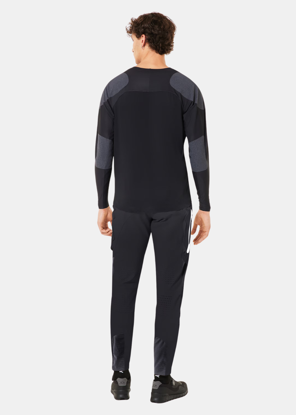 Mannequin de dos en extérieur portant l'ensemble technique Oakley Seeker Edge noir et gris