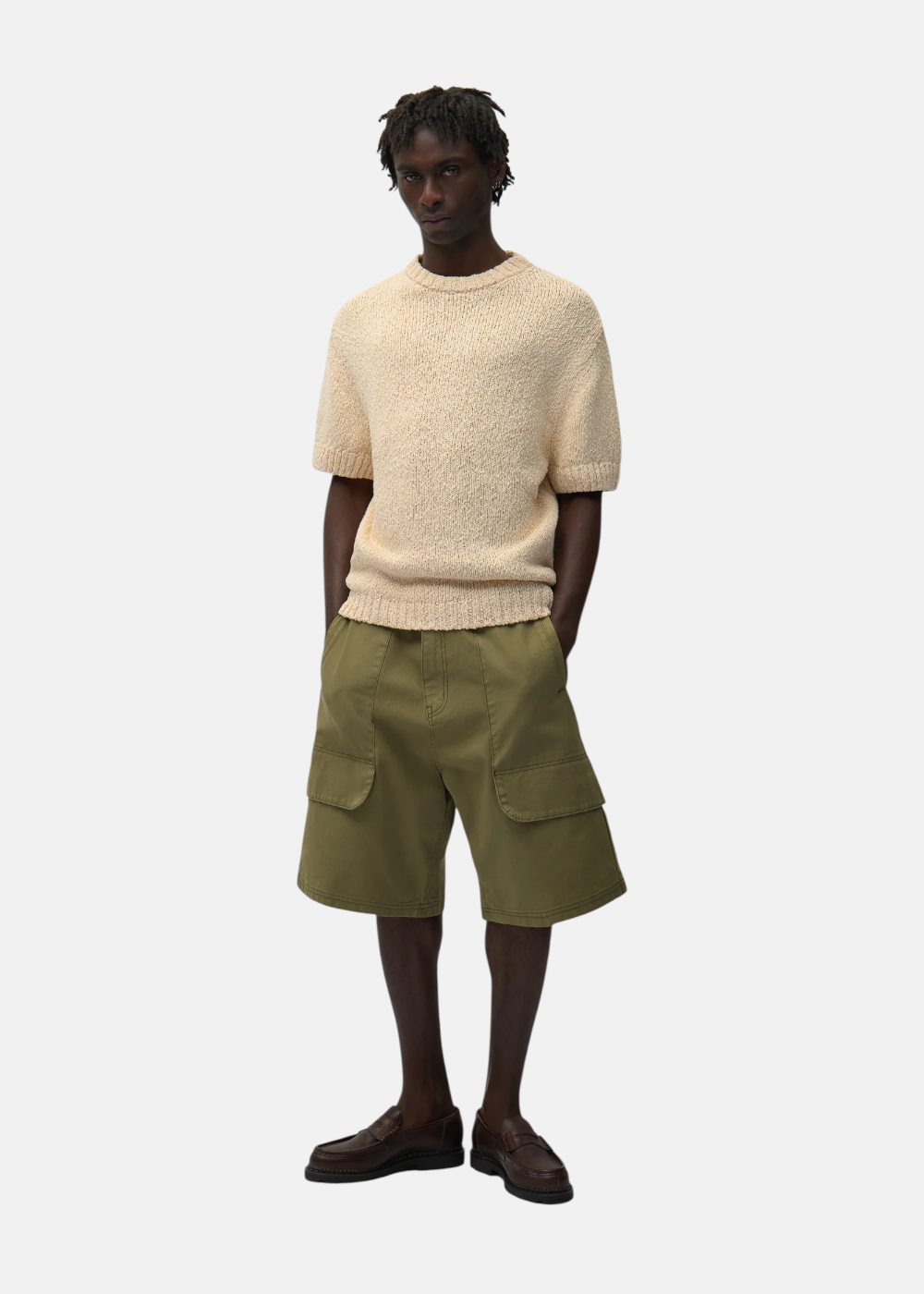 Look complet homme avec t-shirt en maille beige Arte, bermuda cargo olive et mocassins marrons.