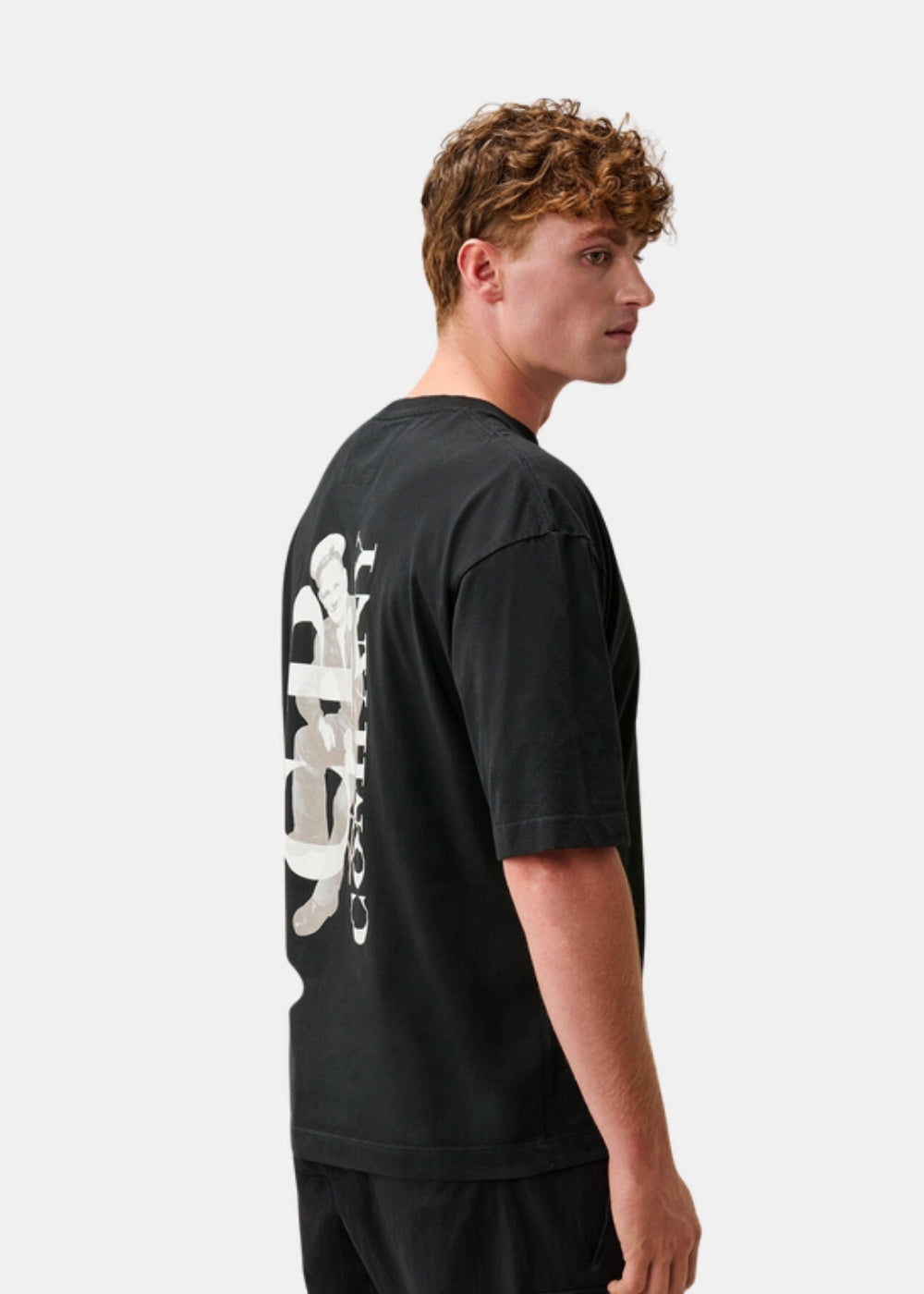 Porté de dos et de profil d'un t-shirt noir C.P. Company montrant le grand motif British Sailor imprimé en blanc dans le dos.