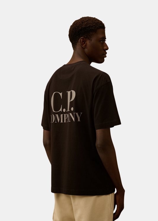 T-shirt Homme noir C.P. Company porté de dos avec un grand logo blanc imprimé au centre.