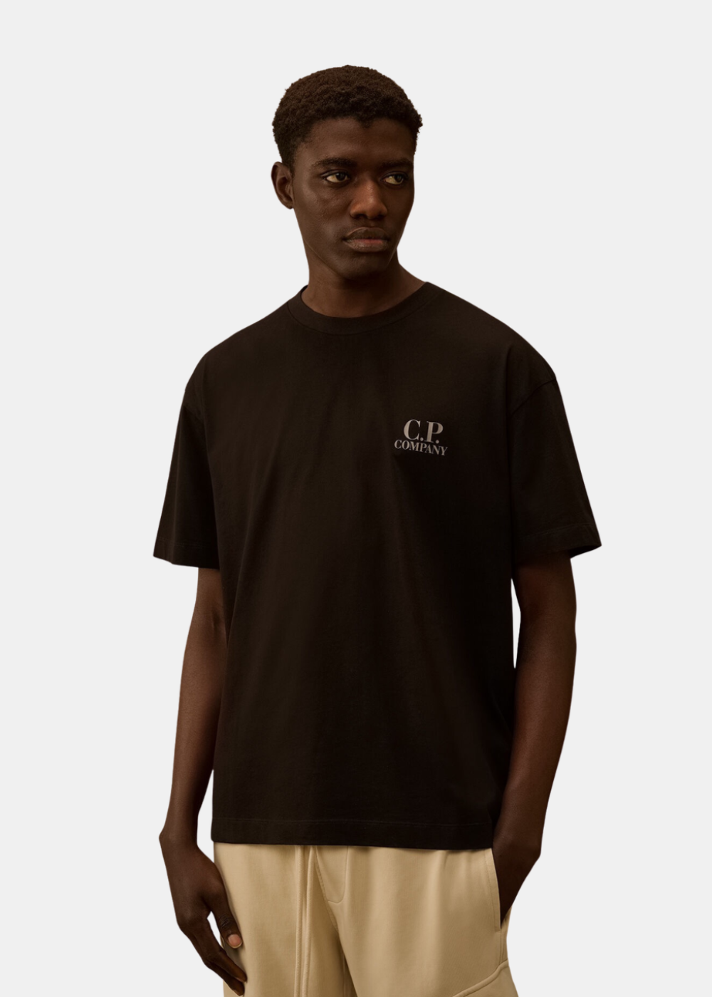 T-shirt Homme noir C.P. Company porté de face mettant en avant le logo de la marque sur la poitrine.