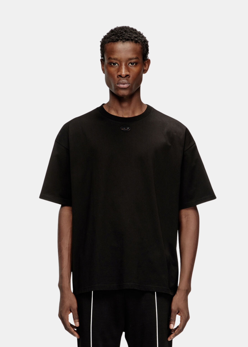 T-shirt noir Diesel col rond avec mini logo Oval D brodé sous l'encolure porté par un mannequin de face