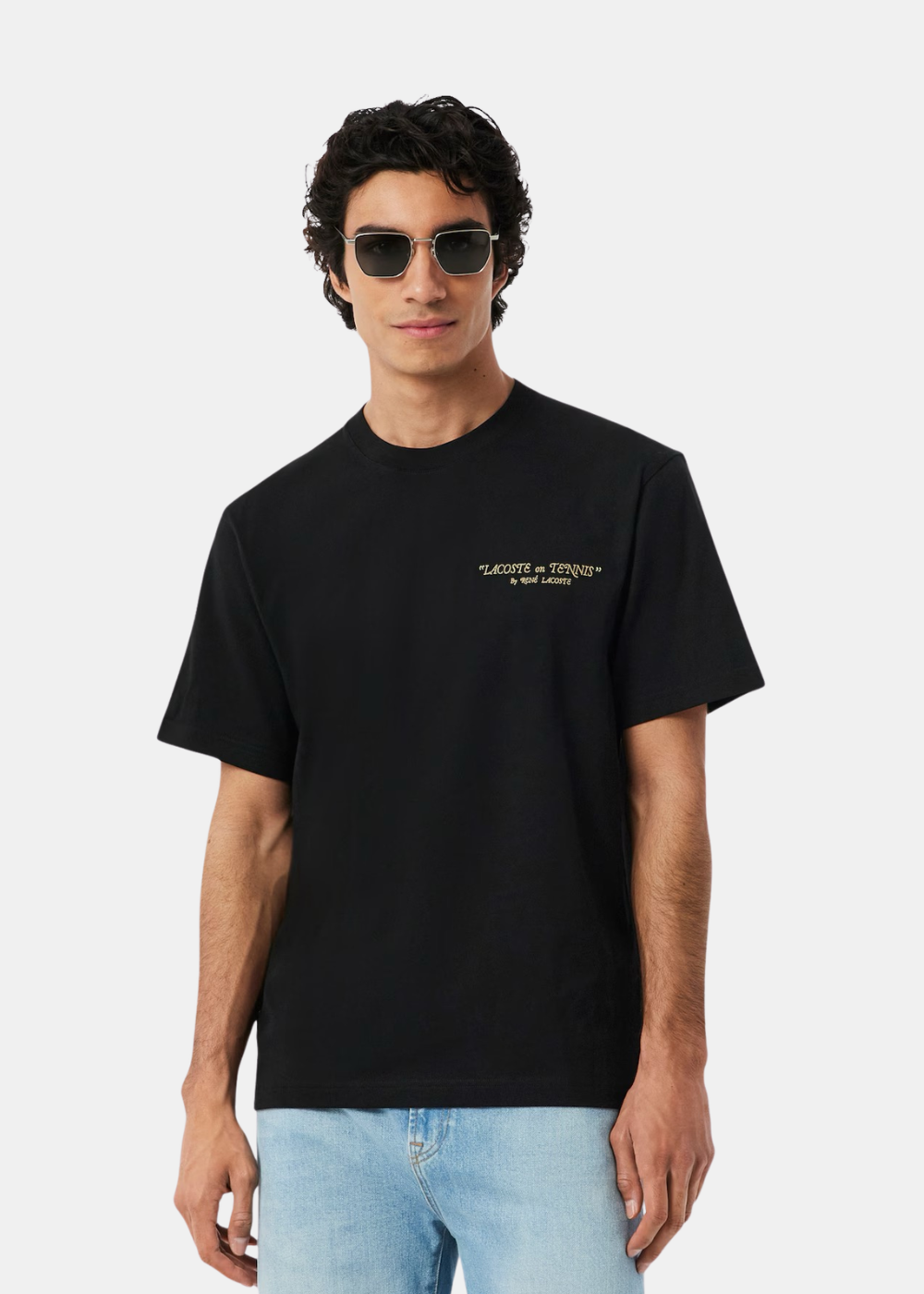Vue de face du t-shirt noir Lacoste porté par un mannequin, mettant l'imprimé.