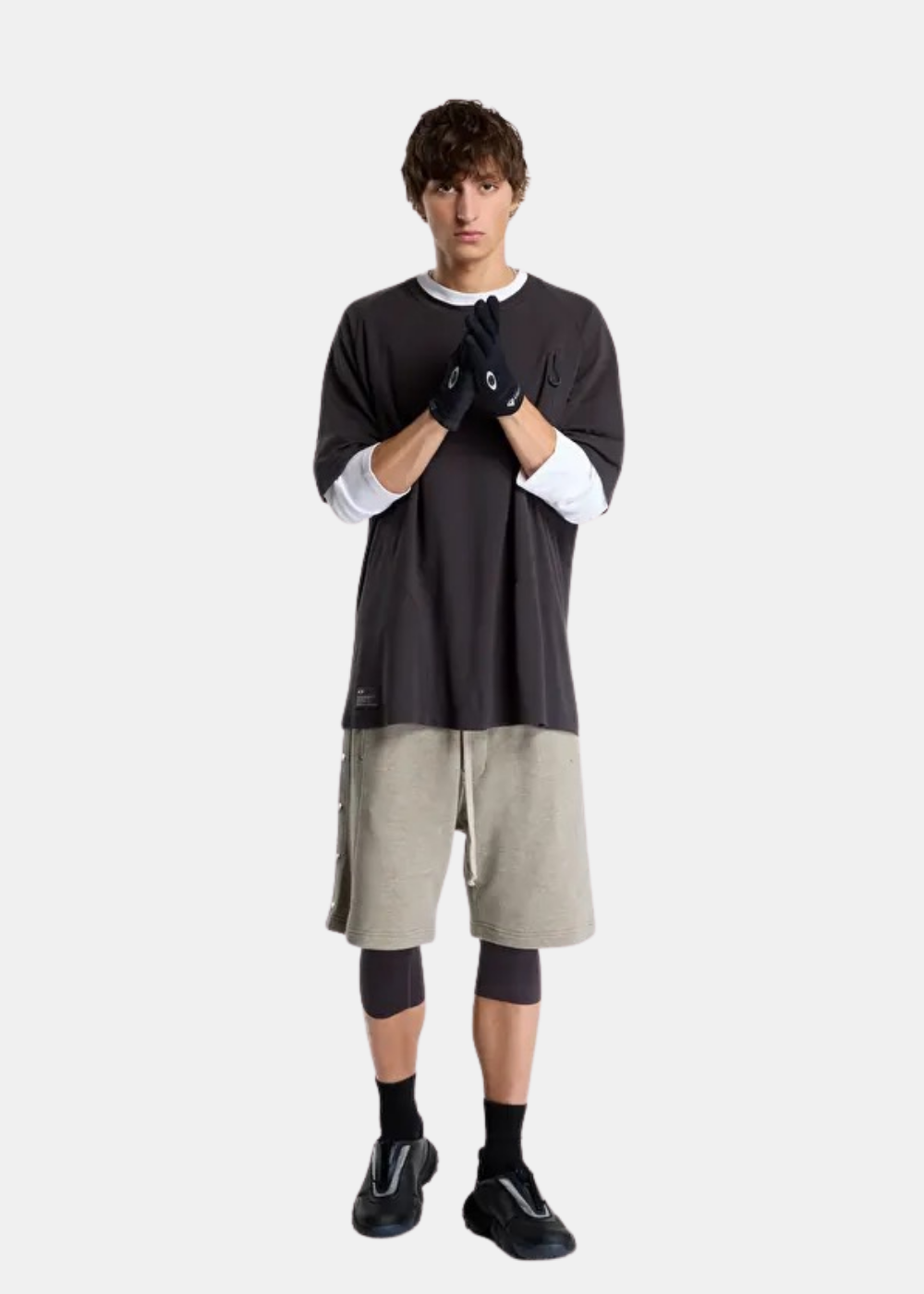 Mannequin en tenue urbaine complète portant le t-shirt Oakley FGL Union 6.7 noir, short gris et gants