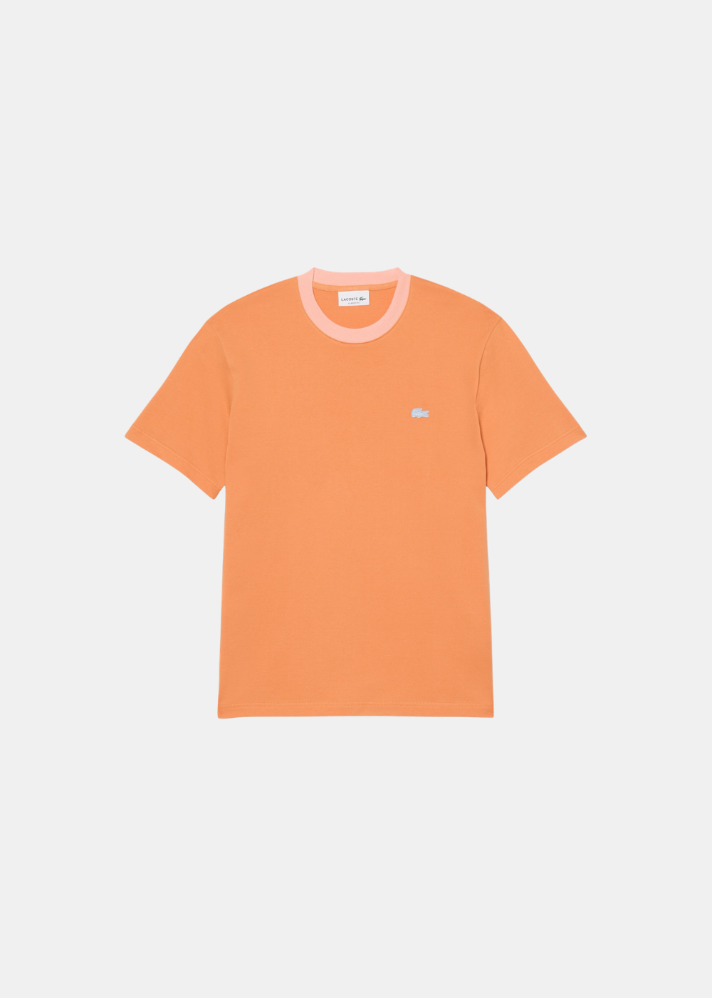 T-shirt Lacoste orange vibrant, col rond rose clair contrasté, petit crocodile bleu clair brodé sur la poitrine. Vue de face à plat sur fond blanc.