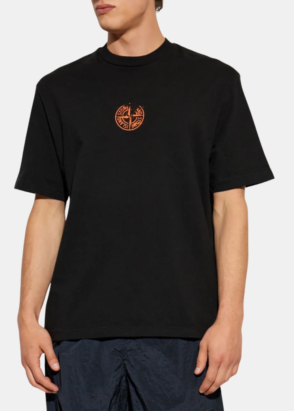 T-shirt noir Stone Island Compass Coordonnées à manches courtes et col rond, porté par un mannequin de face mettant en valeur le logo boussole orange sur la poitrine.