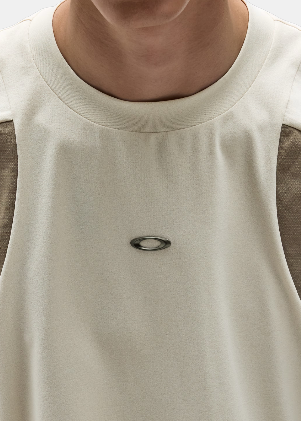 Gros plan sur le col rond et le petit logo Ellipse Oakley métallisé au centre de la poitrine