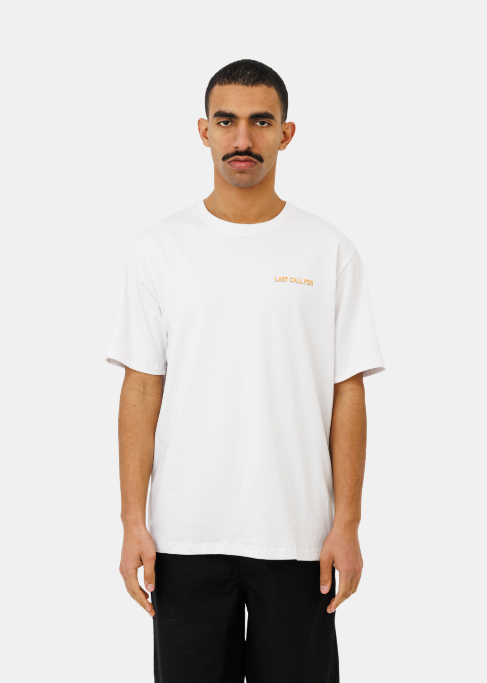 T-shirt blanc en coton avec broderie jaune sur la poitrine, porté de face par un mannequin