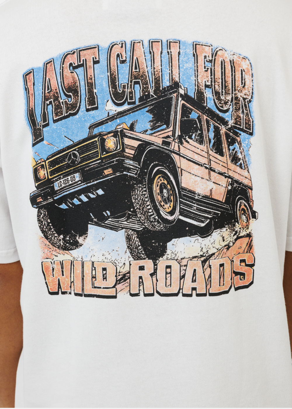 Gros plan sur le grand imprimé graphique rétro représentant un 4x4 et l'inscription Wild Roads