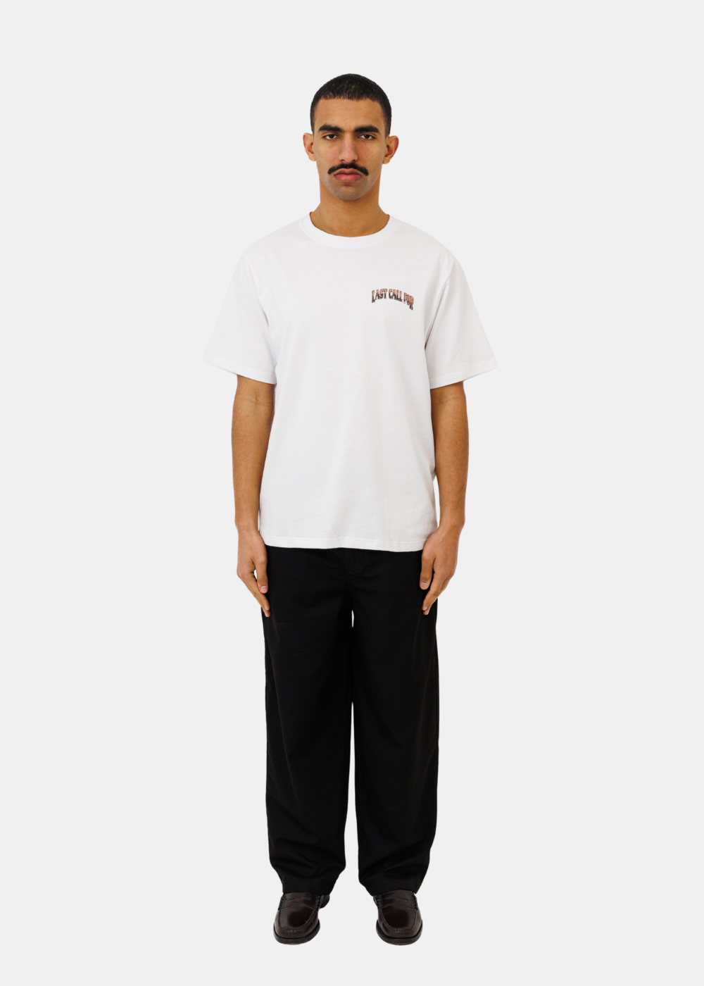 Mannequin portant le t-shirt blanc Last Call For avec un pantalon noir et des mocassins
