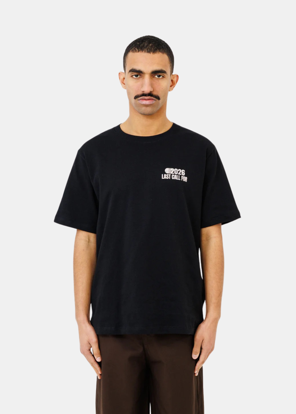 T-shirt noir en coton avec petit logo blanc Last Call For 2026 sur la poitrine, porté de face