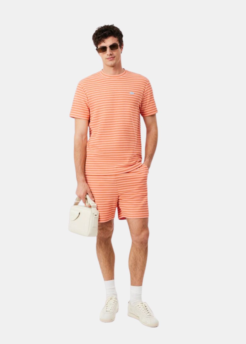 mannequin en total look Lacoste avec son short et son T-shirt à rayures - orange